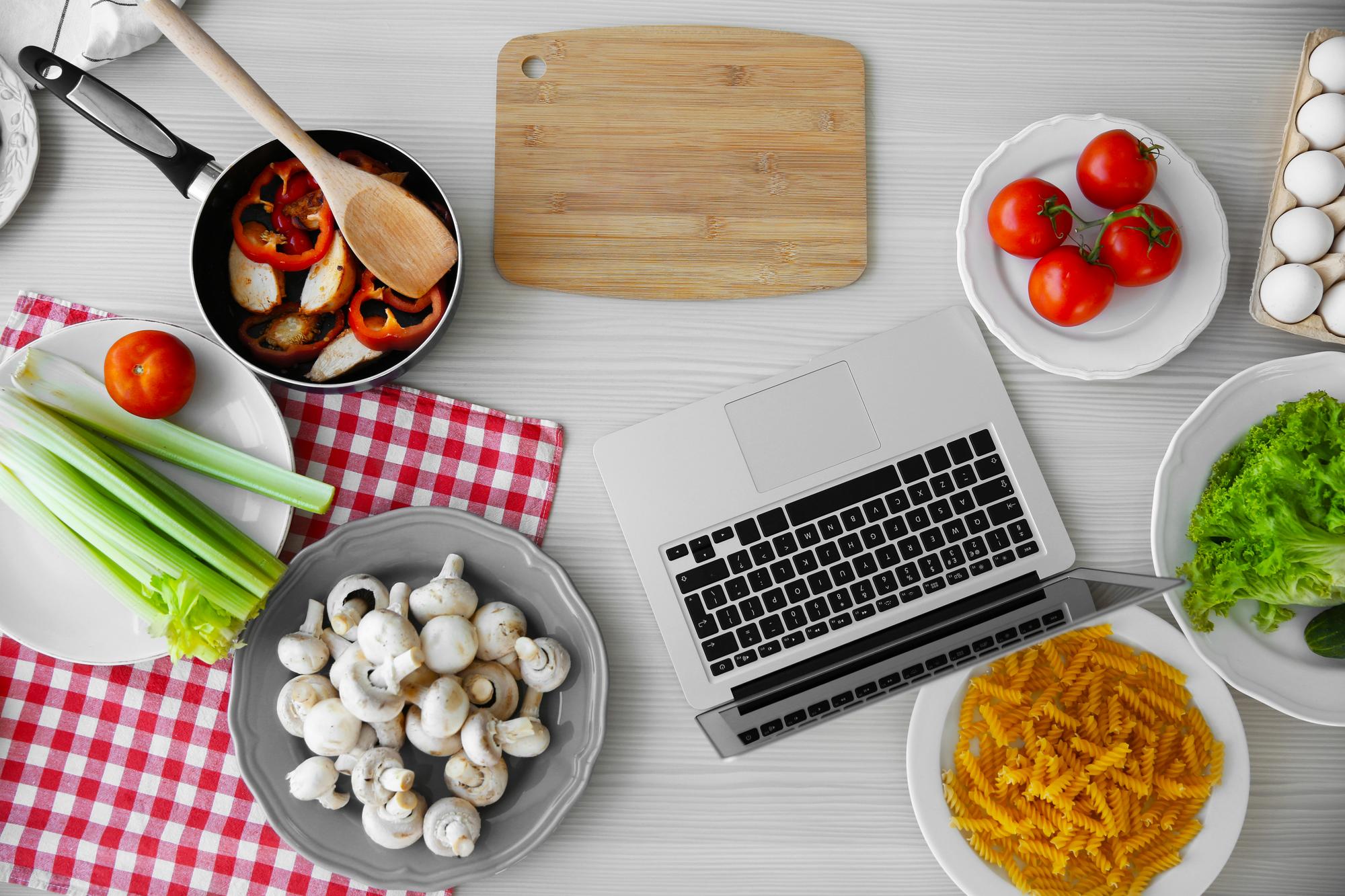 Modern kitchen workspace with laptop and ingredients