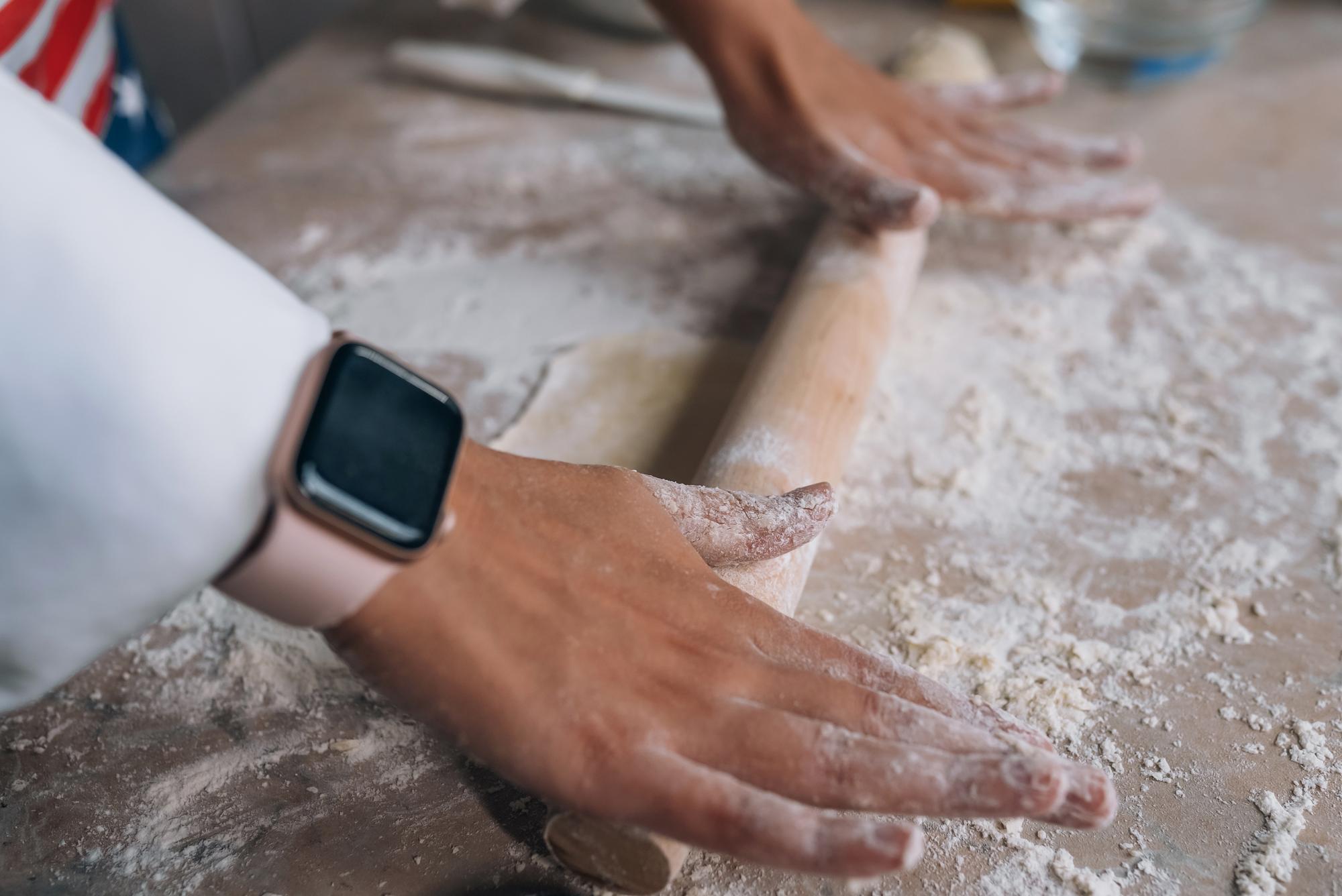Close up of hands preparing dough with scale
